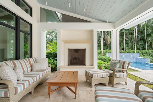 sunroom featuring lofted ceiling and an outdoor fireplace