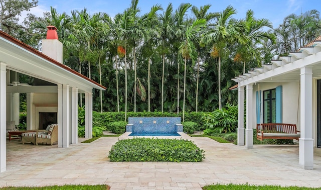 view of pool featuring a patio and exterior fireplace