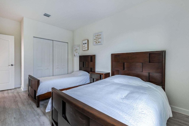 bedroom with a closet and light hardwood / wood-style floors