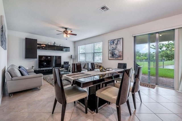 dining space with ceiling fan, light tile patterned floors, and a textured ceiling