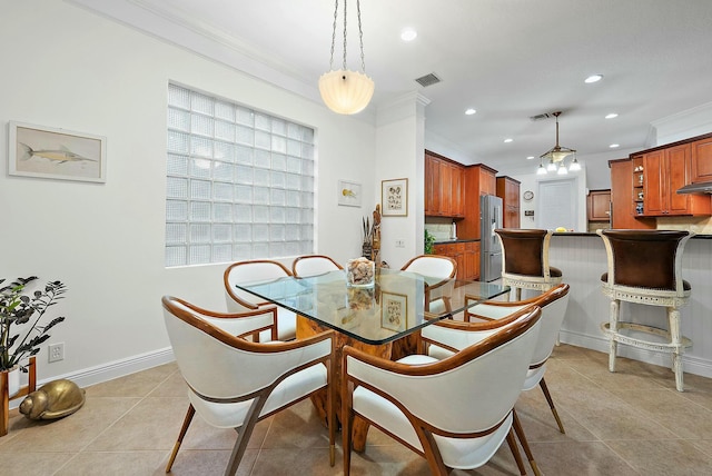 tiled dining area with ornamental molding and a healthy amount of sunlight