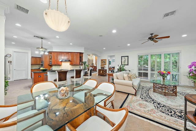 dining area featuring ceiling fan, ornamental molding, and light tile patterned flooring