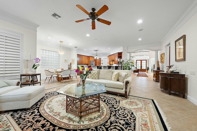 living room featuring ceiling fan, light tile patterned floors, ornamental molding, and ornate columns