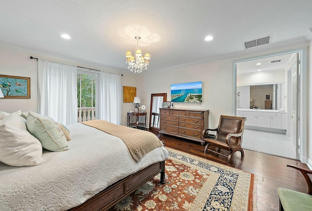 bedroom with ornamental molding, a chandelier, dark hardwood / wood-style floors, and ensuite bath