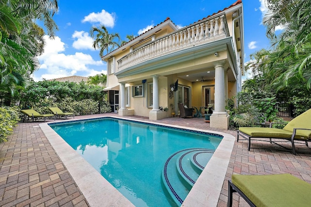 view of swimming pool with ceiling fan and a patio