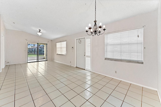 empty room with vaulted ceiling, light tile patterned flooring, a textured ceiling, and an inviting chandelier