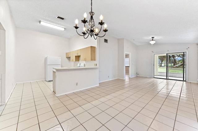 kitchen with lofted ceiling, white refrigerator, a textured ceiling, light tile patterned flooring, and light brown cabinets