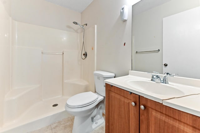 bathroom with tile patterned floors, toilet, vanity, and a shower