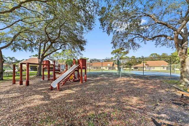 view of jungle gym featuring tennis court