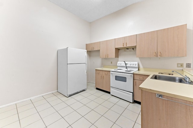 kitchen featuring sink, white appliances, light tile patterned floors, high vaulted ceiling, and light brown cabinetry