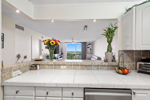 kitchen featuring ceiling fan, white cabinetry, tile countertops, and tasteful backsplash