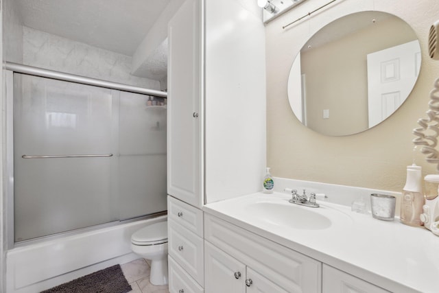 full bathroom featuring tile patterned floors, enclosed tub / shower combo, vanity, and toilet