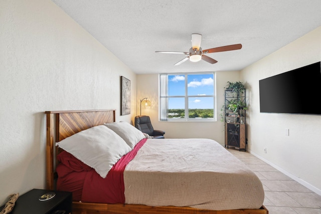 bedroom with ceiling fan, a textured ceiling, and light tile patterned flooring