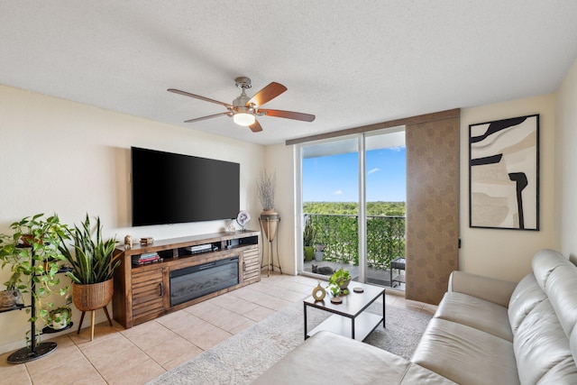 tiled living room with ceiling fan, floor to ceiling windows, and a textured ceiling