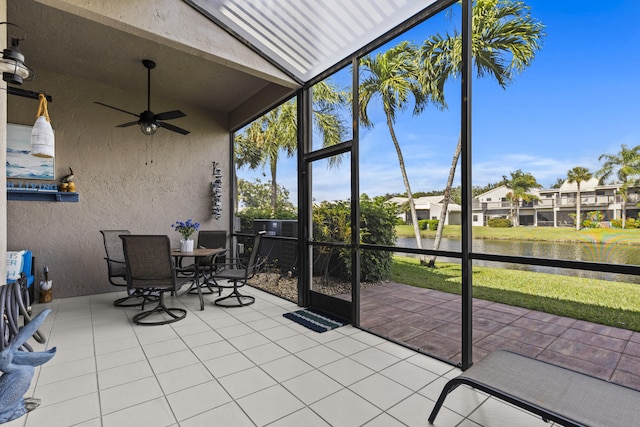 unfurnished sunroom with vaulted ceiling, ceiling fan, and a water view