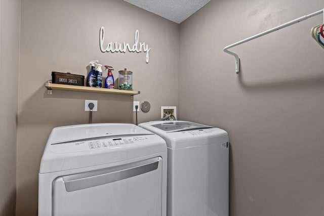 laundry room featuring washer and clothes dryer and a textured ceiling