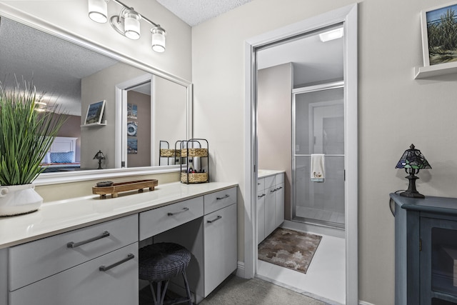 bathroom with vanity, a textured ceiling, and walk in shower