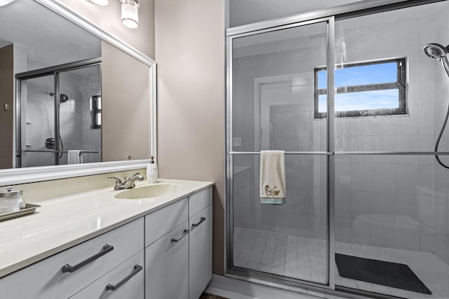 bathroom featuring vanity and a shower with door