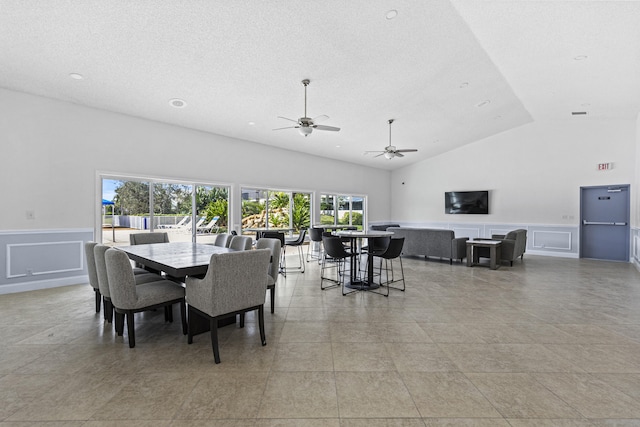 dining area with high vaulted ceiling, light tile patterned floors, and a textured ceiling