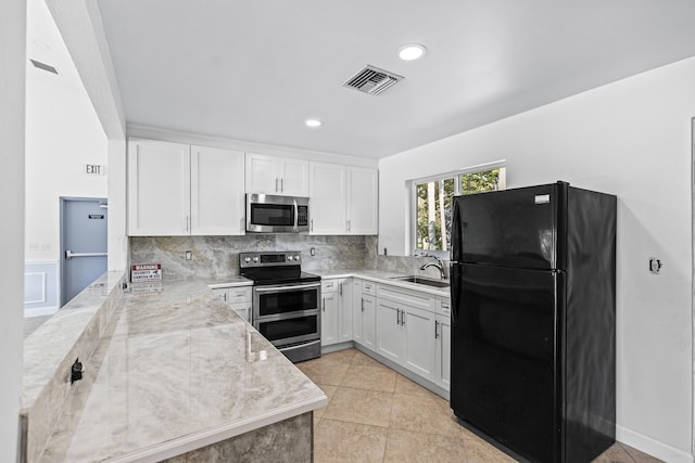 kitchen featuring white cabinets, stainless steel appliances, sink, backsplash, and light stone counters