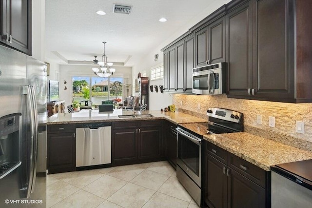 kitchen featuring an inviting chandelier, light tile patterned floors, kitchen peninsula, stainless steel appliances, and hanging light fixtures