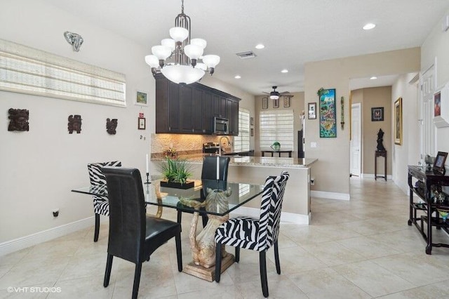 tiled dining area with ceiling fan with notable chandelier