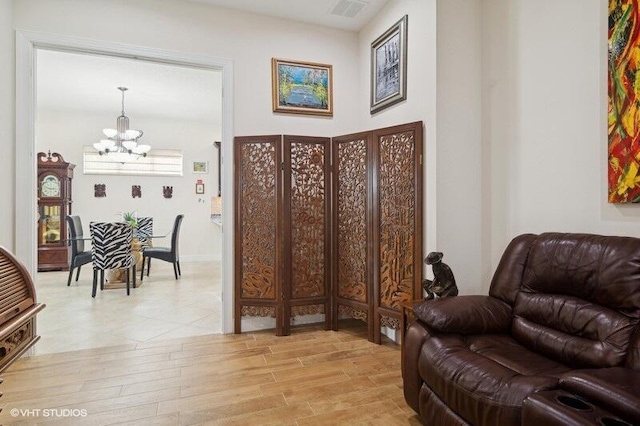 sitting room featuring light hardwood / wood-style floors and a notable chandelier