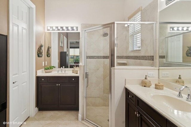 bathroom featuring a shower with shower door and vanity