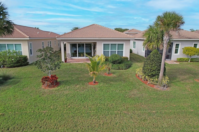 ranch-style home featuring a front lawn and a patio