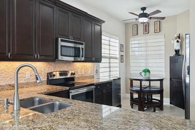 kitchen featuring light stone counters, sink, appliances with stainless steel finishes, and tasteful backsplash