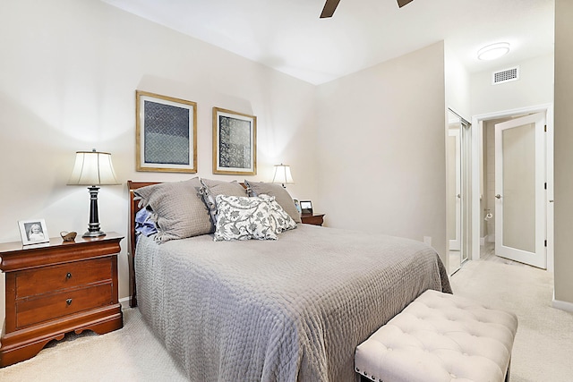 bedroom with ceiling fan, connected bathroom, and light carpet