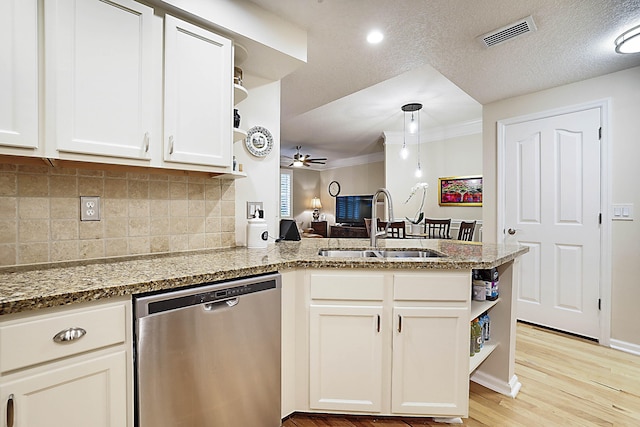 kitchen with sink, kitchen peninsula, dishwasher, light stone countertops, and white cabinets