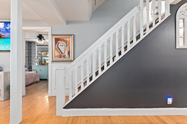 staircase with ceiling fan and hardwood / wood-style floors