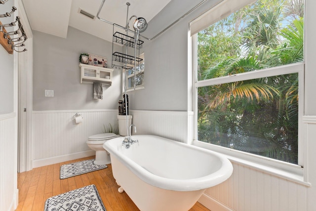 bathroom with wood-type flooring, toilet, and a bathing tub