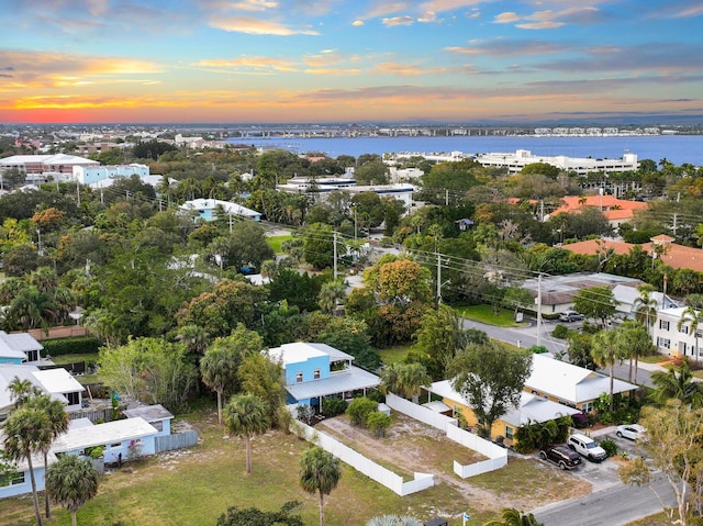 aerial view at dusk featuring a water view