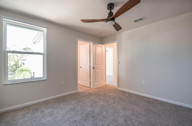 unfurnished bedroom featuring ceiling fan, a textured ceiling, and light carpet