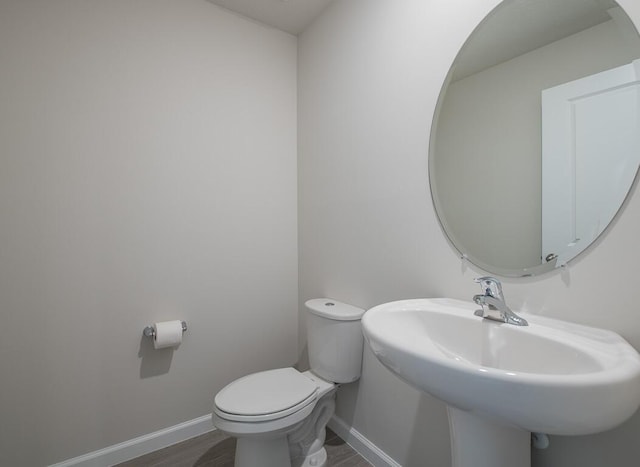 bathroom featuring toilet, hardwood / wood-style flooring, and sink