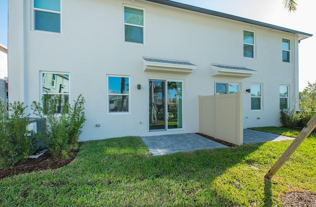 back of property with a patio area and a lawn