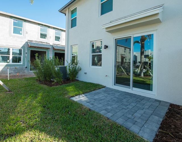 rear view of property featuring central AC, a yard, and a patio