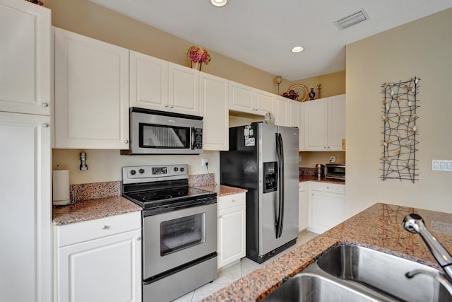 kitchen featuring white cabinetry, sink, light stone counters, and appliances with stainless steel finishes