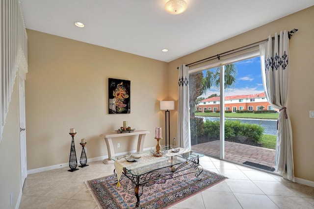 sitting room with a water view and light tile patterned floors