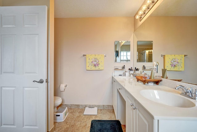 bathroom featuring vanity, a shower with door, tile patterned floors, and a textured ceiling