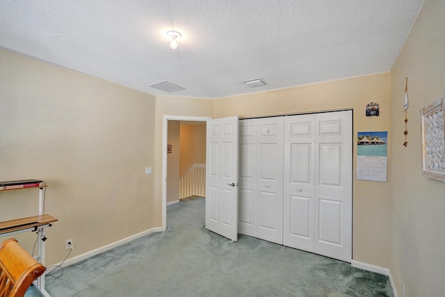 carpeted bedroom featuring a textured ceiling and a closet