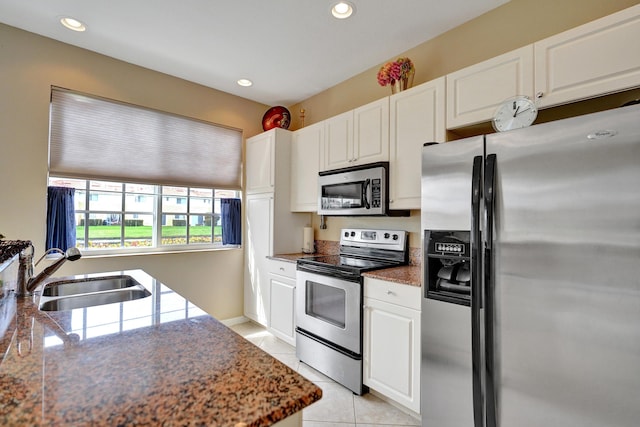 kitchen with light tile patterned flooring, stainless steel appliances, sink, and white cabinets