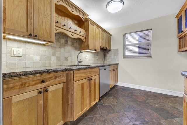 kitchen featuring sink, backsplash, dishwasher, and dark stone countertops