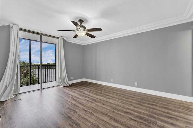 spare room with wood-type flooring, expansive windows, ceiling fan, and ornamental molding