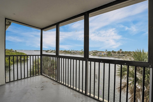 unfurnished sunroom featuring a water view