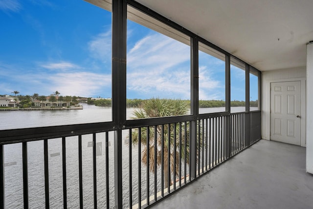 unfurnished sunroom featuring a water view