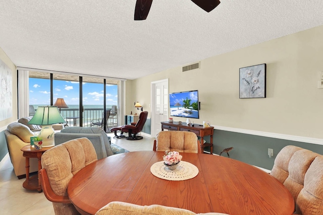 dining room with ceiling fan, a textured ceiling, and floor to ceiling windows