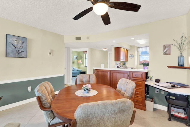 dining room with ceiling fan, light tile patterned flooring, and a textured ceiling